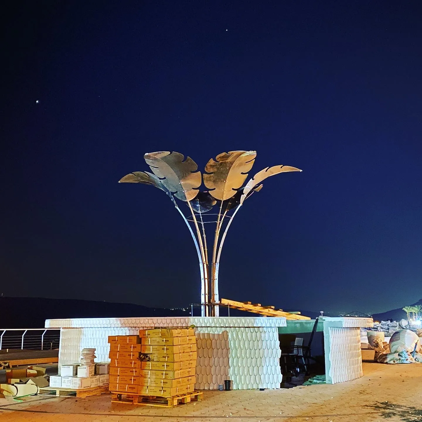Early installation at night — the first leaves mounted on the bare steel stems.