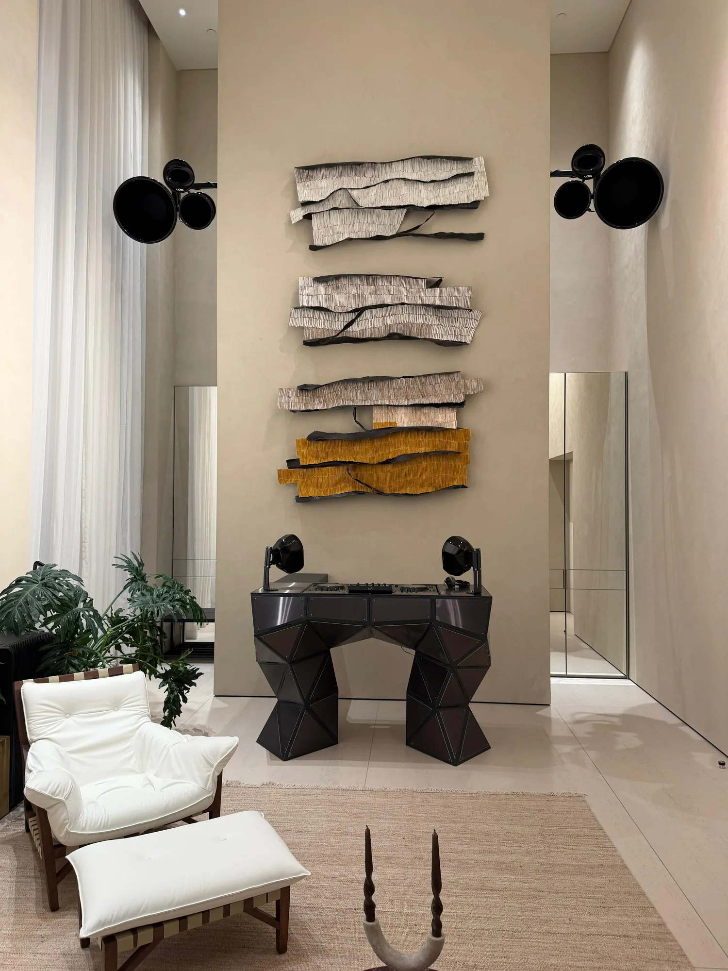 Sculpted metal console standing in a tall daylight room
