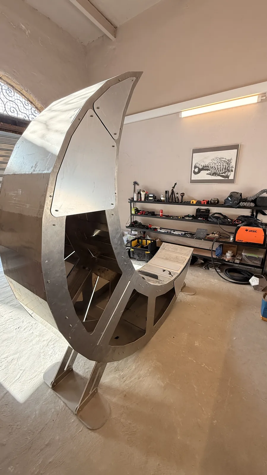 Moon Chair before cladding — the exposed structural skeleton of the crescent.